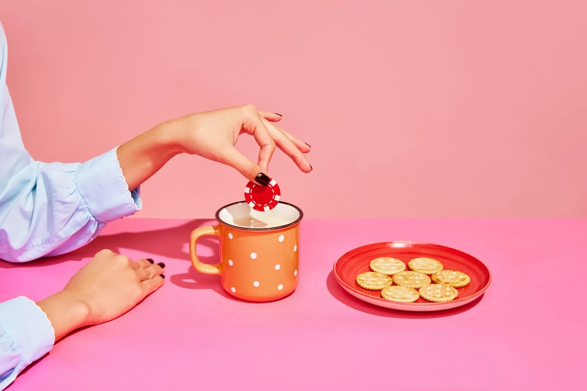 Woman dunking a poker chip in a cup of tea